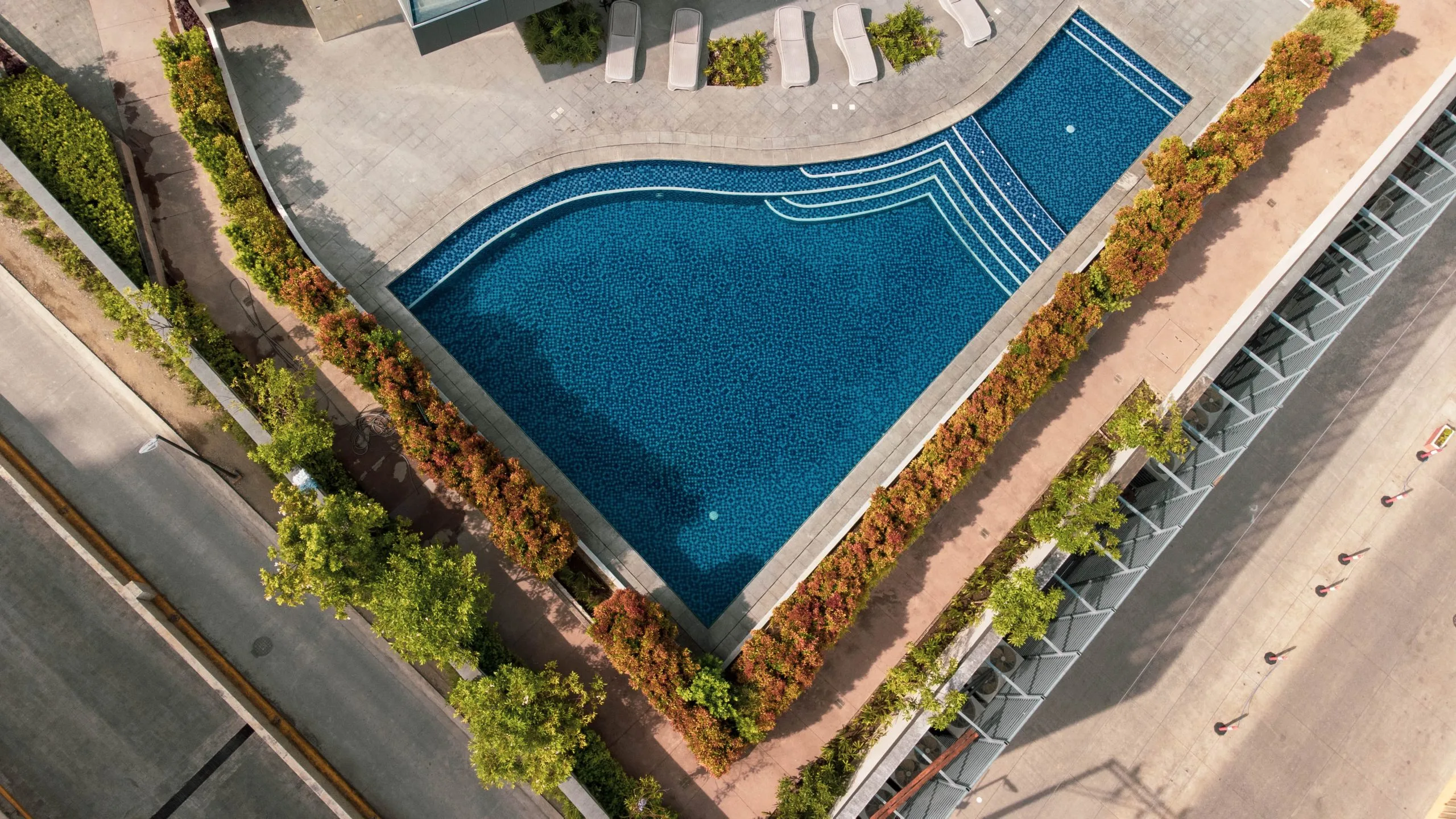 An aerial view of the Club Aeon swimming pool next to a hotel.