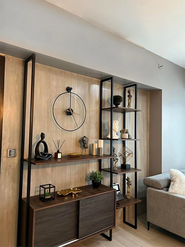 A living room in a condominium with a clock on the wall.