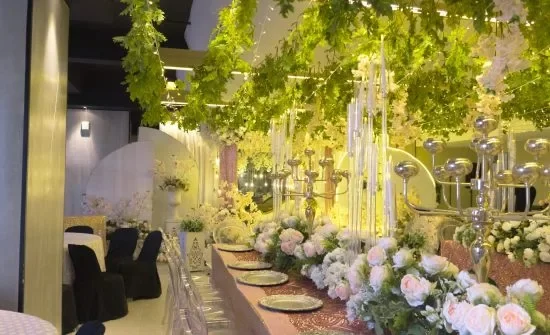 A wedding reception at a hotel with flowers hanging from the ceiling.